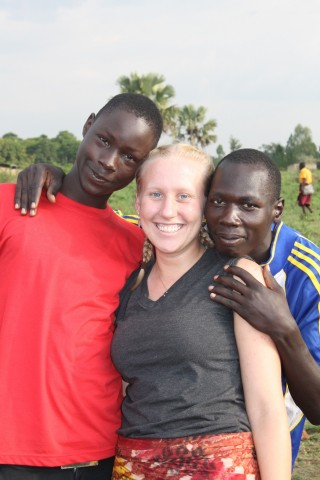 Birdsong (middle) with two of her students at the secondary school: Bonnie (red) and Emmanuel (blue). Birdsong was treating Emma for a strain in his ankle and an infection in his leg. She was also teaching them both how to treat injuries. They were both avid soccer players. 