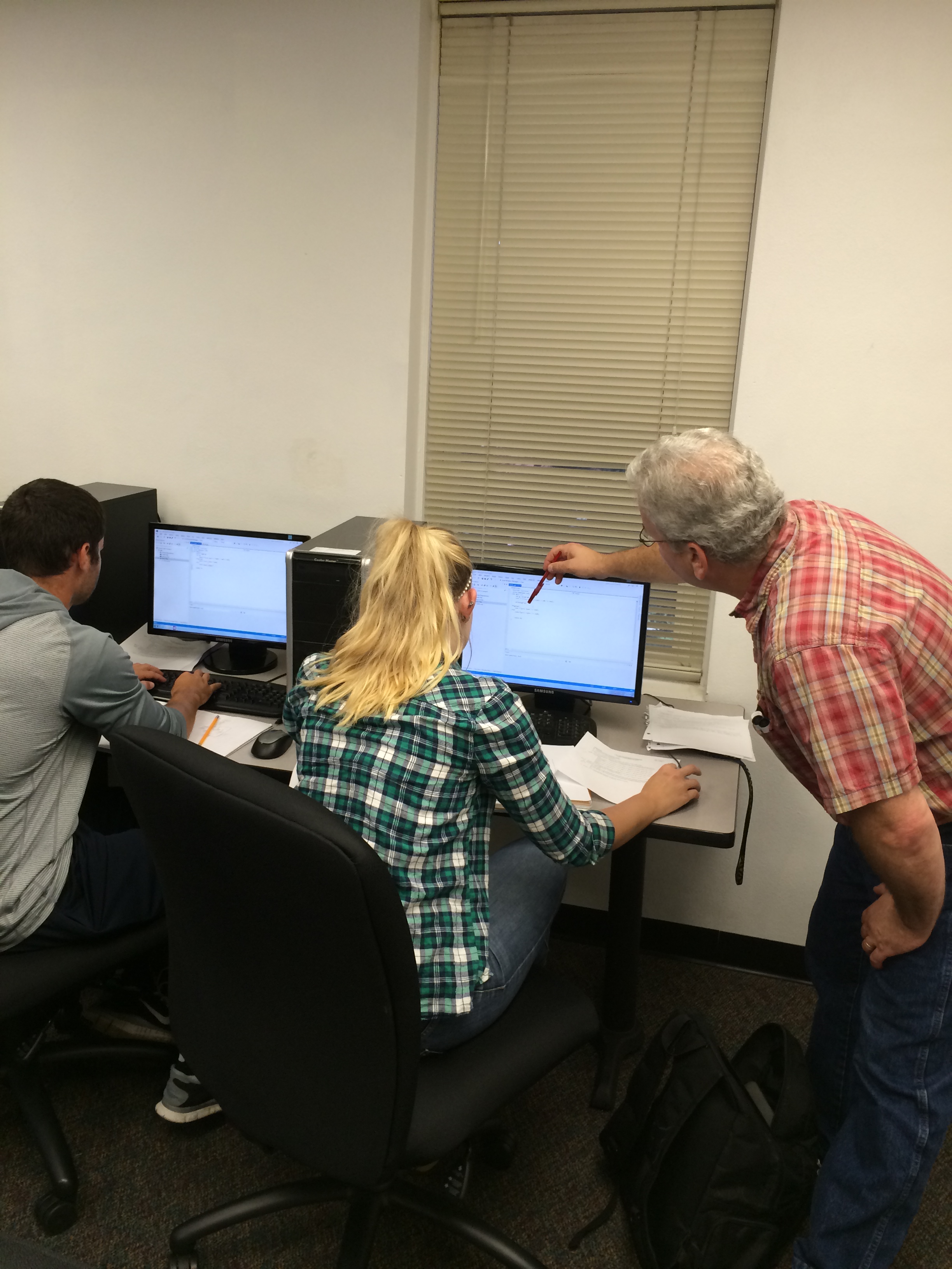 Kian Pokorny, Ph.D. helping a student with her work.